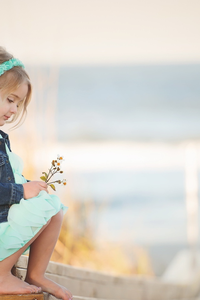 Маленькая девочка сидит на мосту