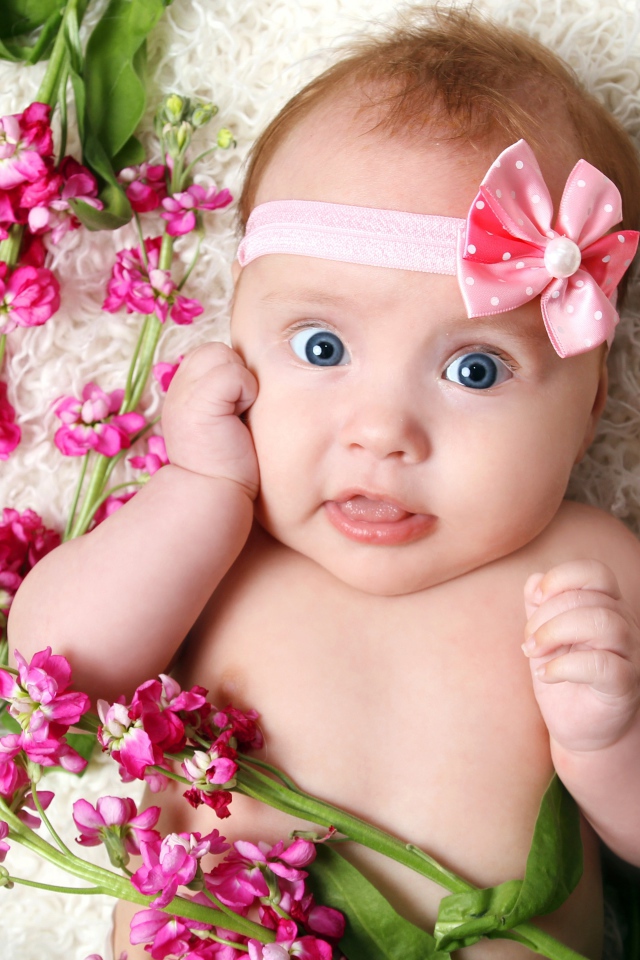 Маленькая девочка с повязкой лежит с розовыми цветами