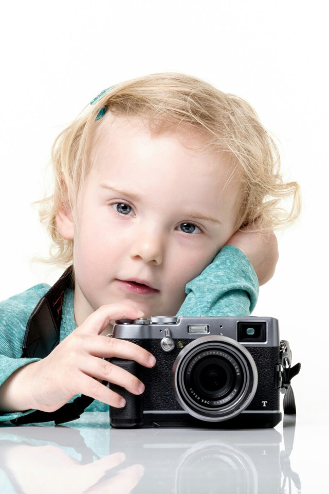 Маленькая девочка с фотоаппаратом на белом фоне