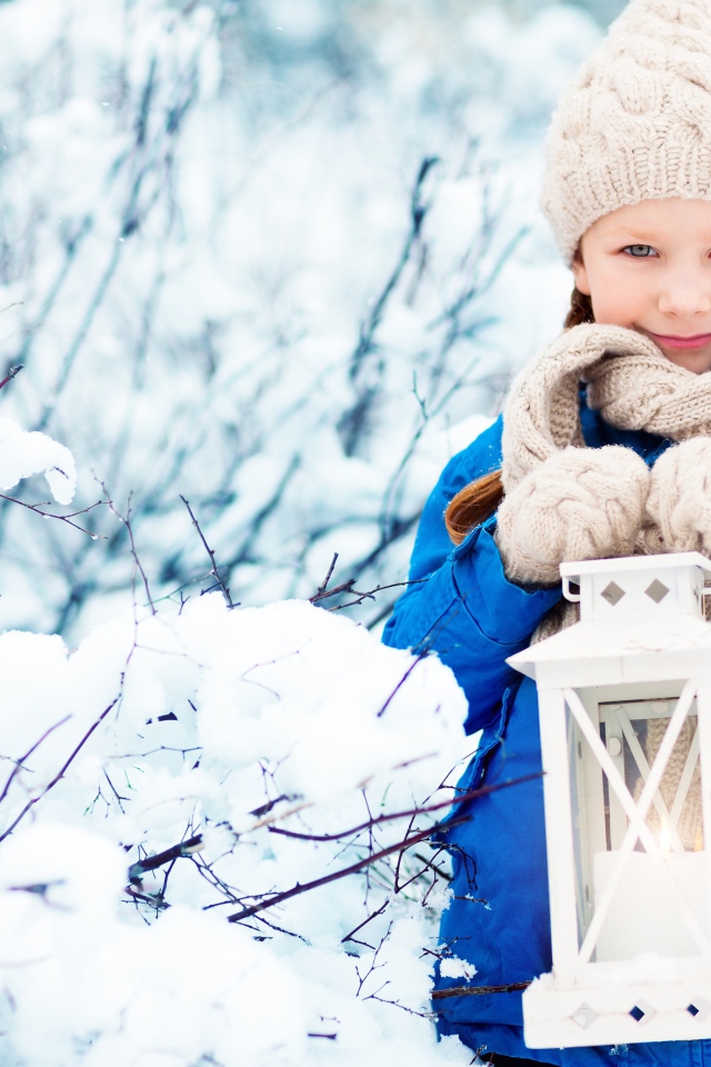 Маленькая девочка с фонарем на улице зимой