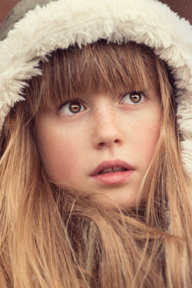 Маленькая девочка с веснушками на лице в капюшоне 