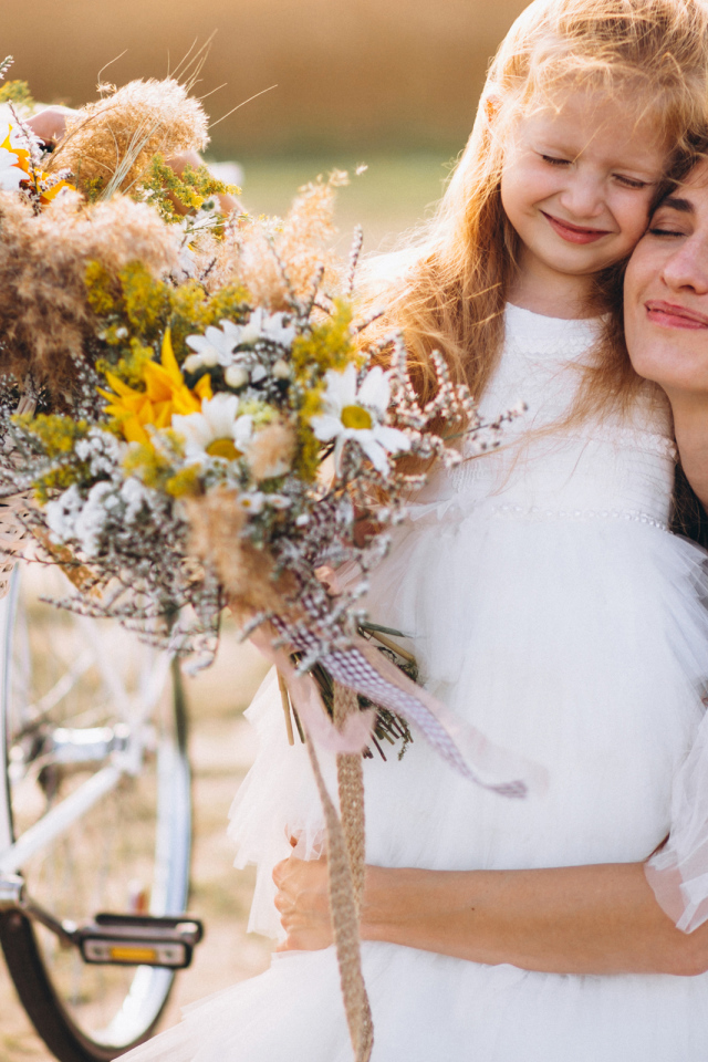 Маленькая девочка с мамой у велосипеда