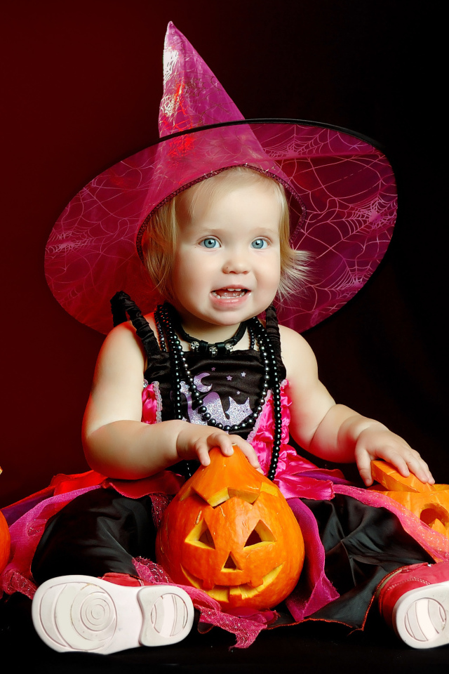 Маленькая девочка с тыквой в костюме на праздник Хэллоуин 