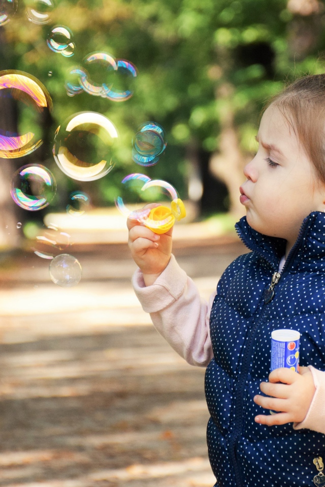 Маленькая девочка  с мыльными пузырями 