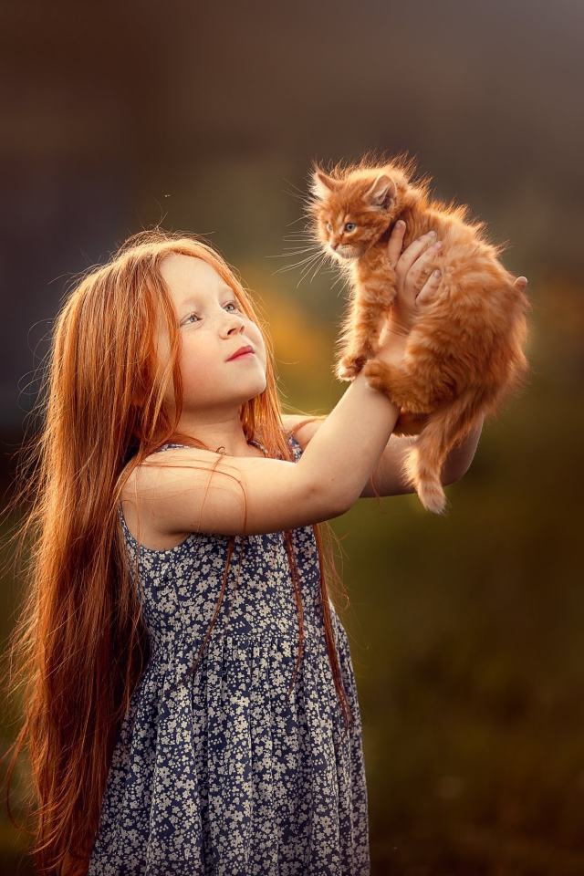 Маленькая рыжеволосая девочка с рыжим котенком в руках
