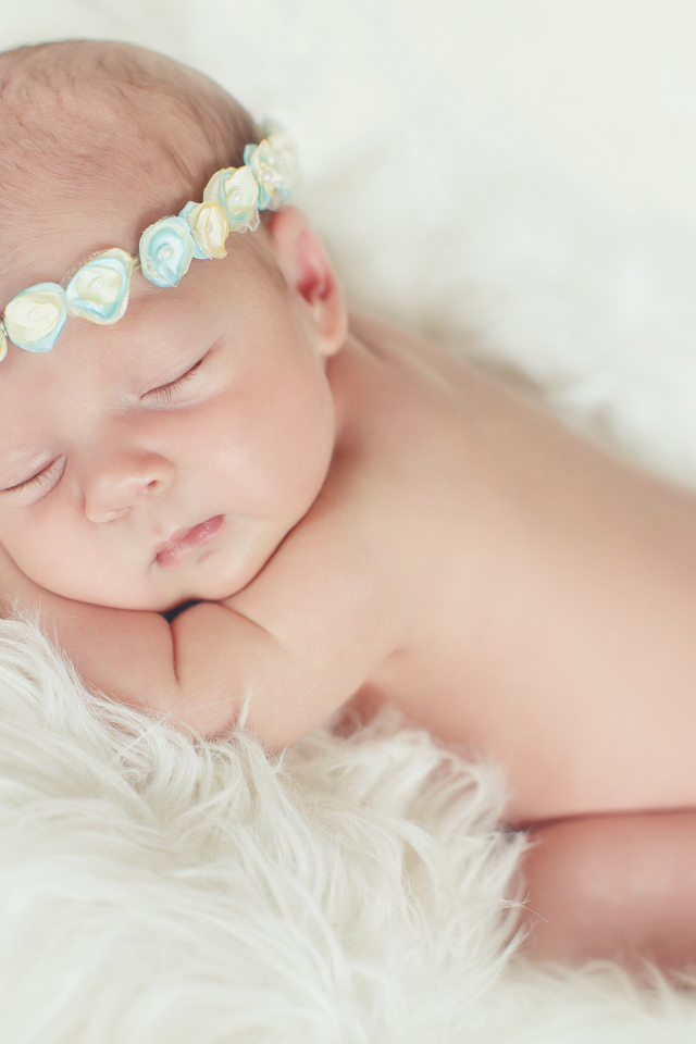 Маленький спящий ребенок на меховом покрывале