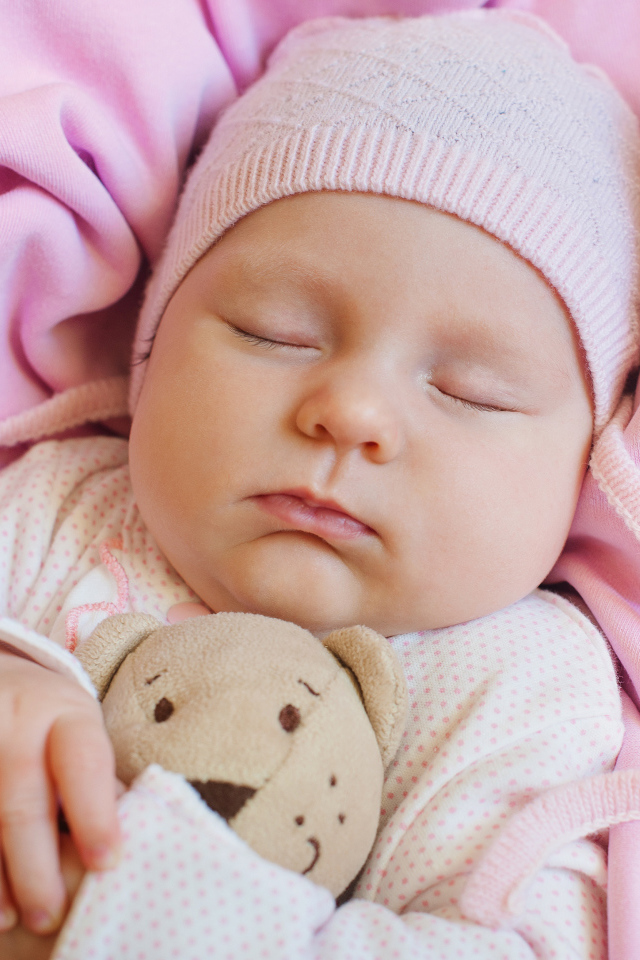 Спящий ребенок обнимает любимую игрушку