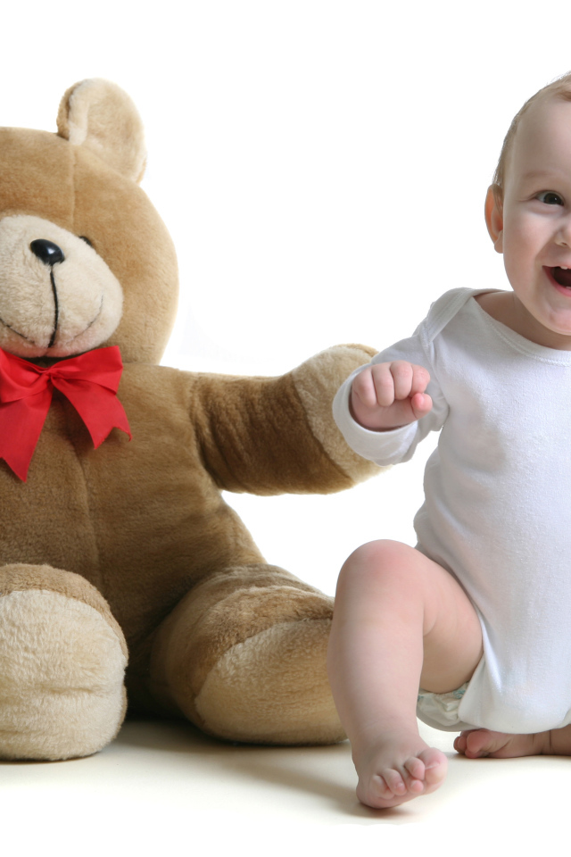 Улыбающийся малыш в большим игрушечным медведем