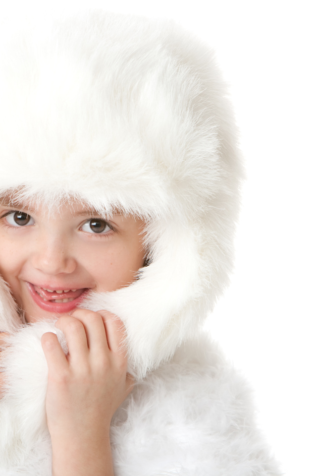 Улыбающаяся маленькая девочка в белой меховой шапке