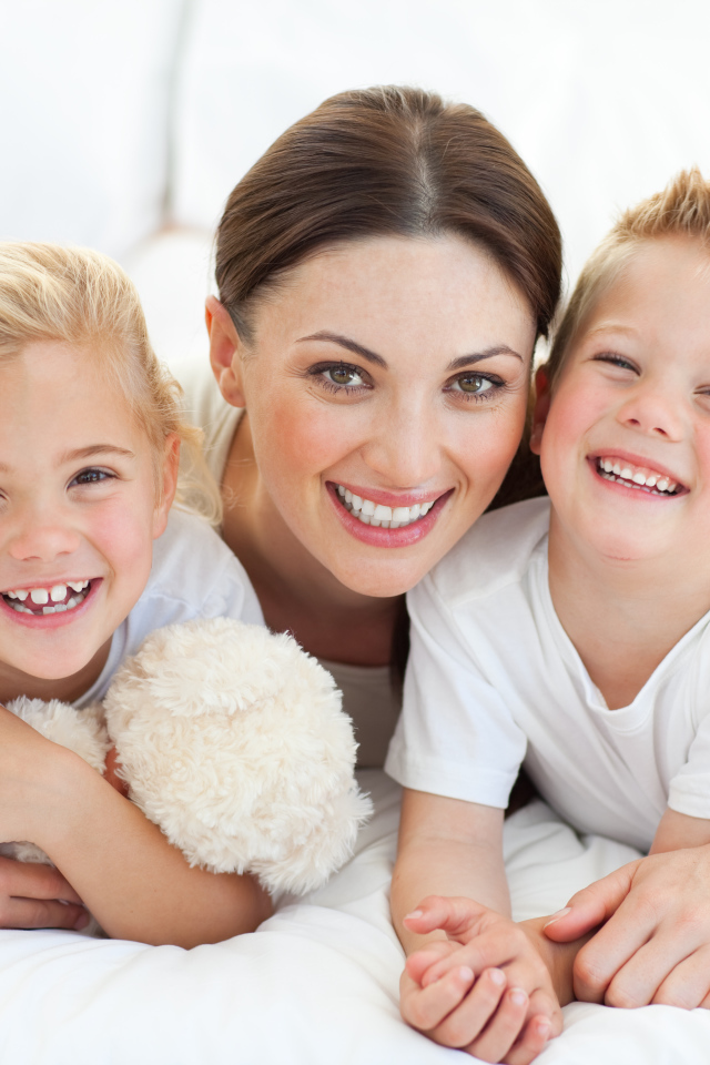 Улыбающаяся мама с двумя детьми