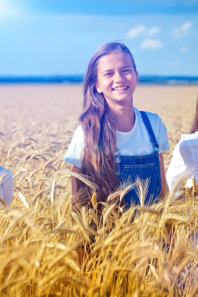 Три девочки на поле с желтой пшеницей