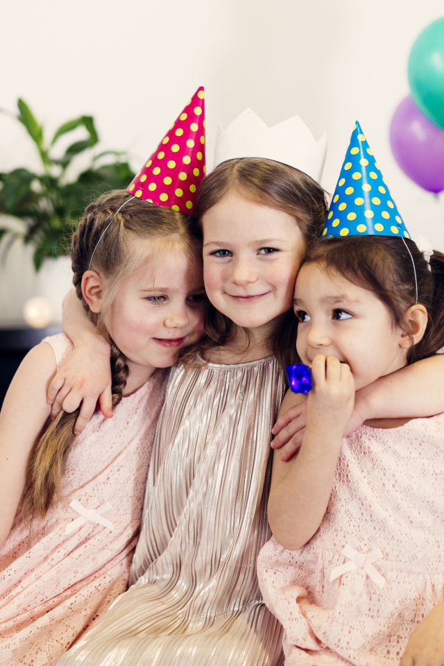 Три маленькие девочки в праздничных колпаках