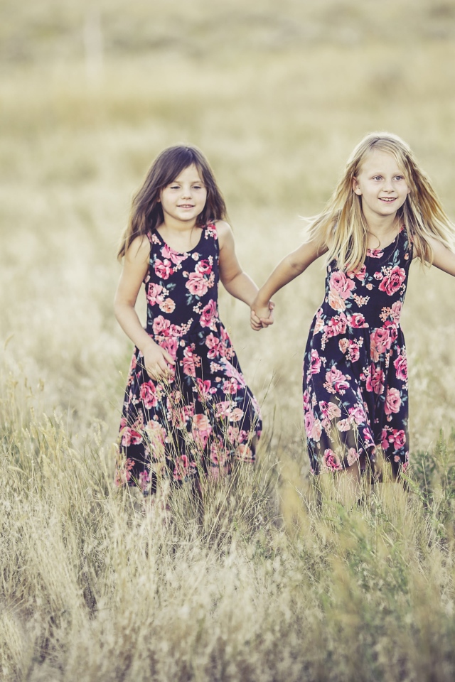 Две маленькие девочки бегут по траве