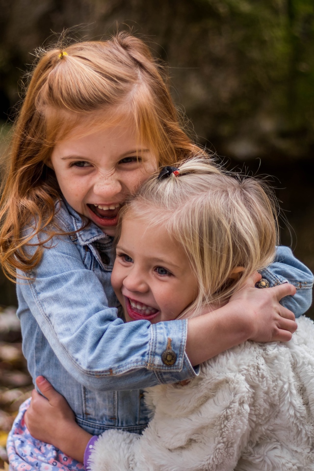 Две маленькие сестры обнимают друг друга 