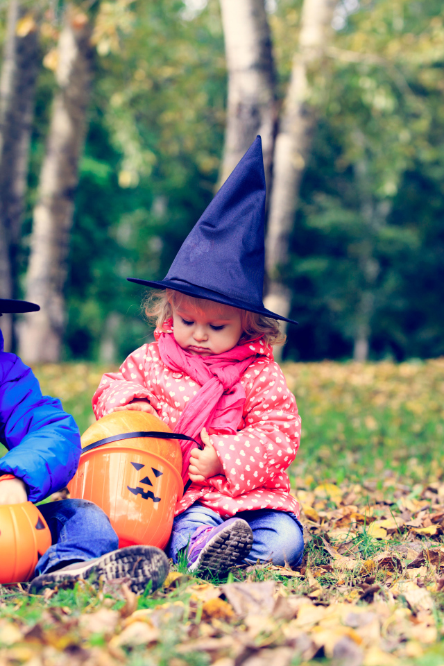 Маленькие мальчик и девочка в лесу на Хэллоуин 