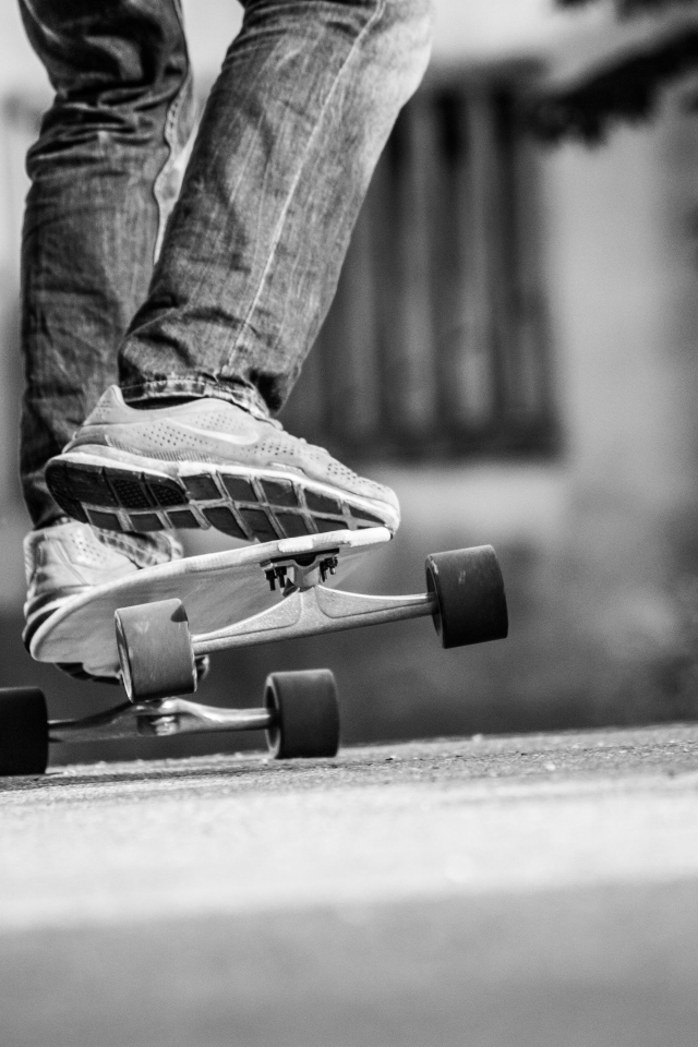 Парень катается на скейтборде по асфальту