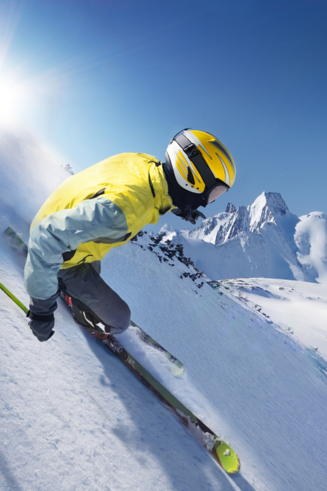 The skier in the helmet goes down the snow-covered slope