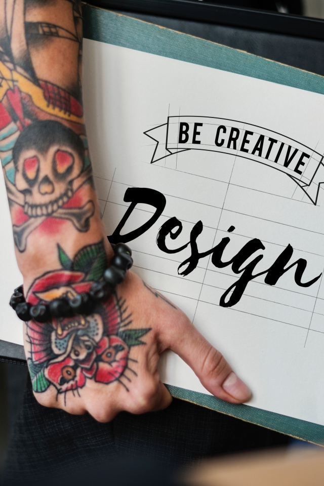 Мужчина с татуировкой на руке держит папку