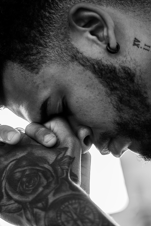 Мужчина с татуировками на руке и шее