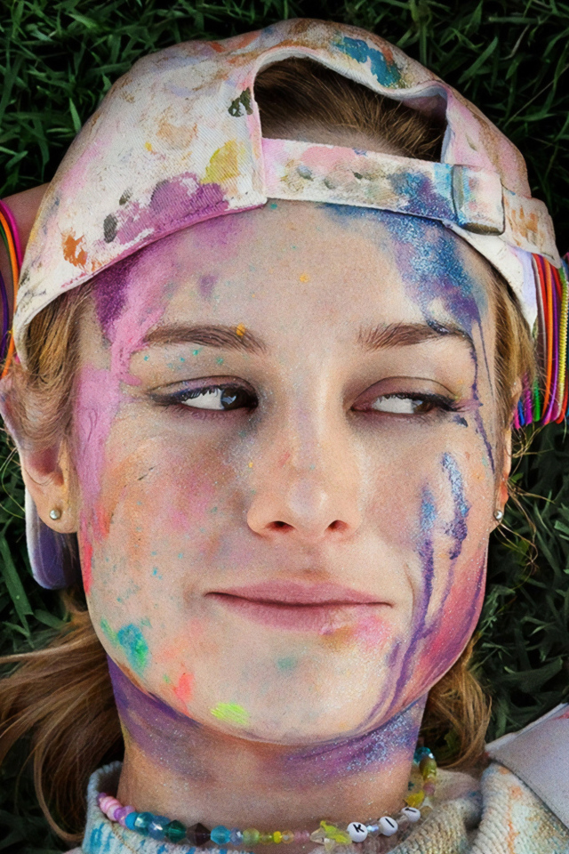 Актриса Бри Ларсон с лицом в краске лежит на траве