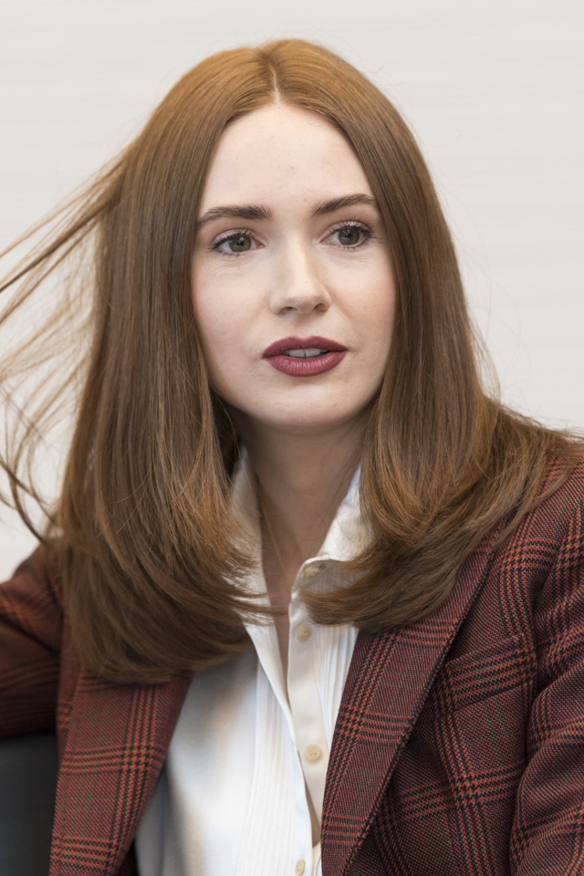 Актриса Карен Гиллан в пиджаке держит волосы