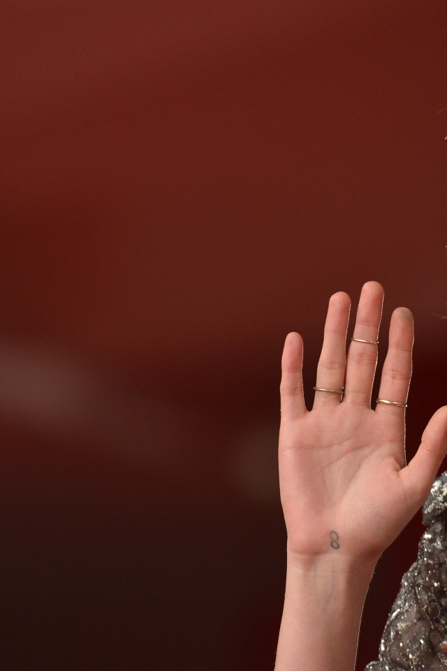 Актриса Кристен Стюарт с поднятой рукой