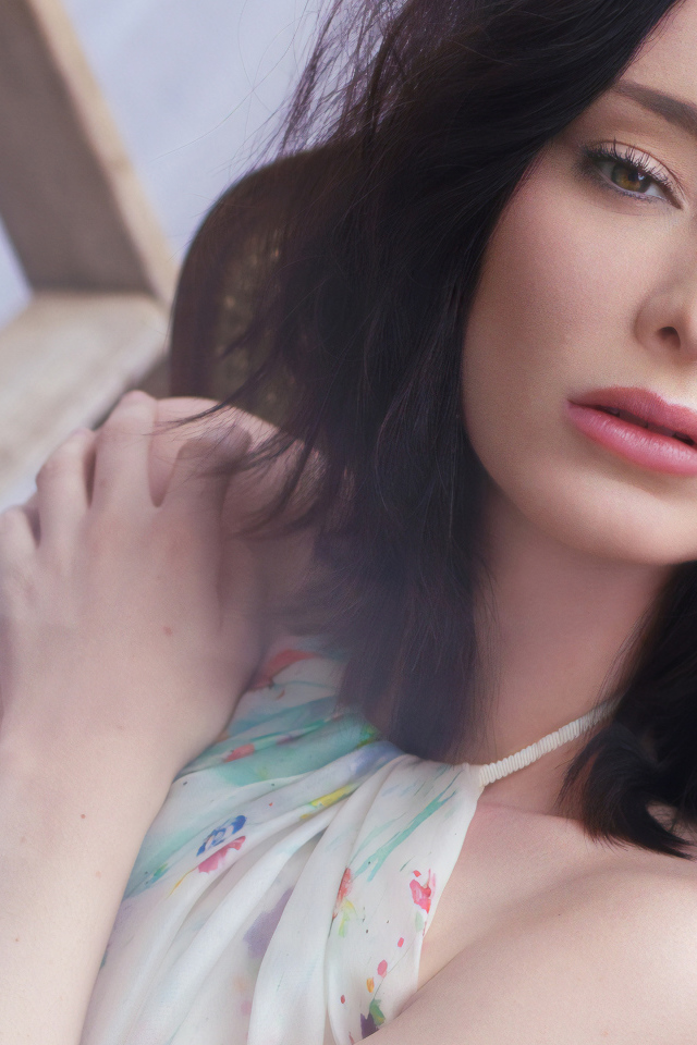 Красивая брюнетка, актриса Эмма Дюмон сидит на стуле 