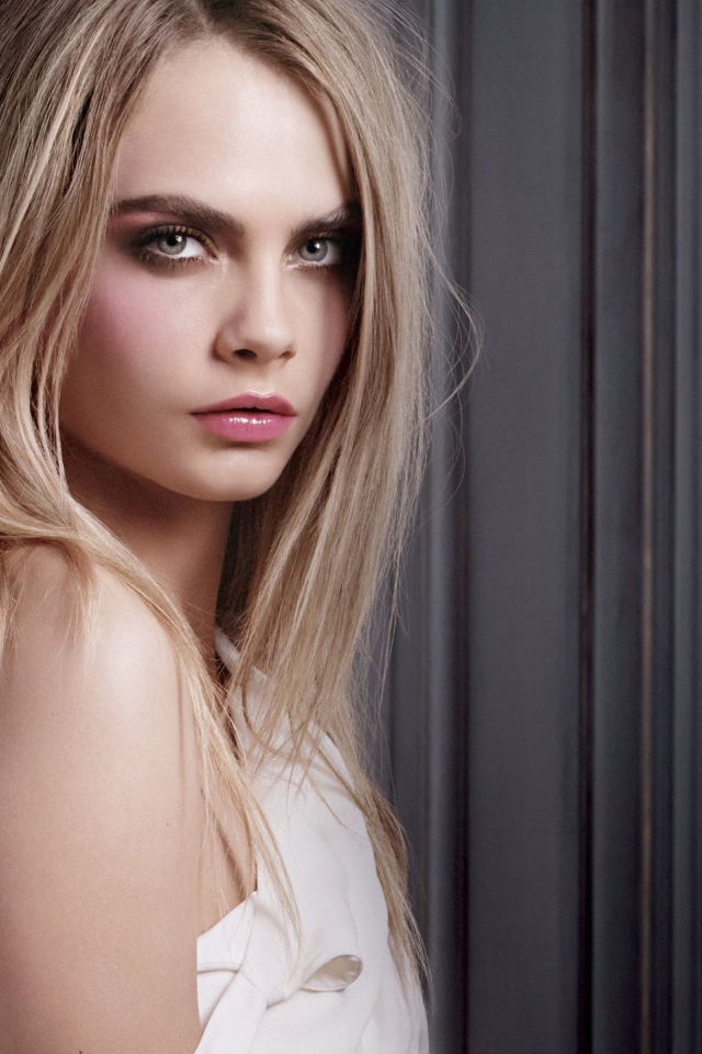 Красивая девушка, актриса Кара Делевинь у стены