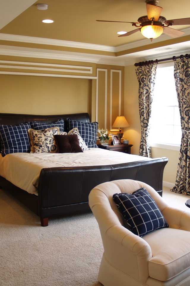 Спальня с большой кожаной кроватью и креслами 