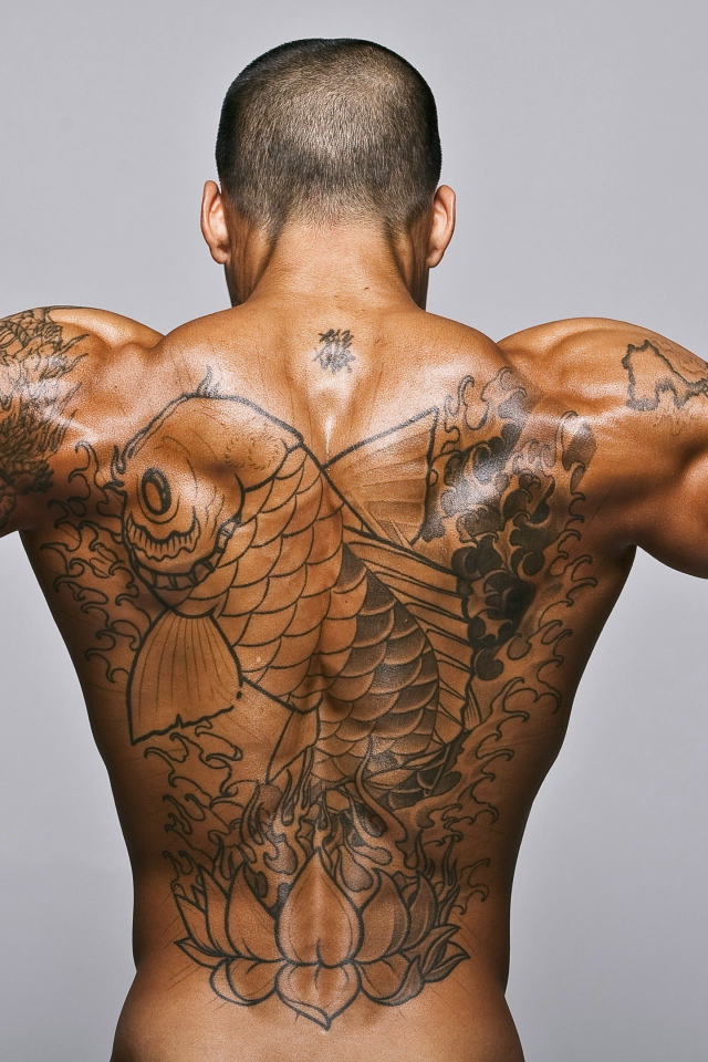 Большая татуировка с рыбой на спине у мужчины