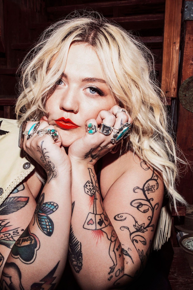 Blue-eyed blonde with tattoos on her arms