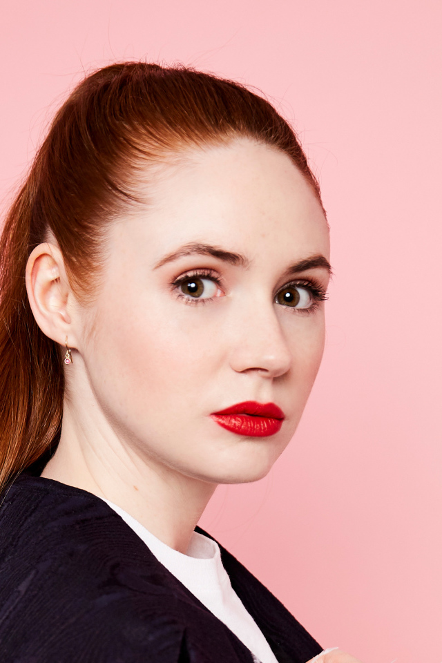 Яркая рыжеволосая девушка, актриса Карен Гиллан на розовом фоне