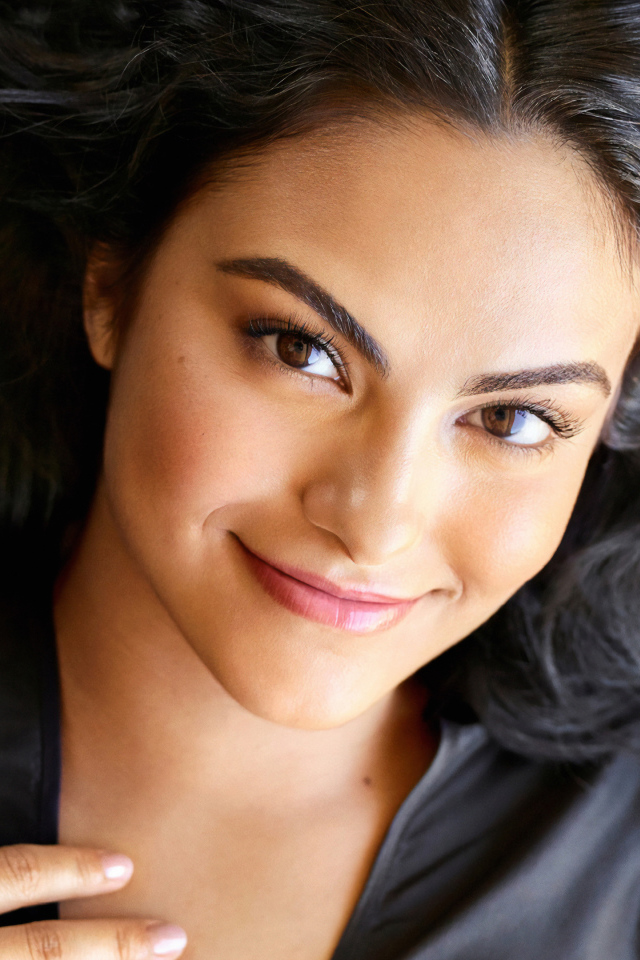 Кареглазая актриса Камила Мендес лежит на кровати 