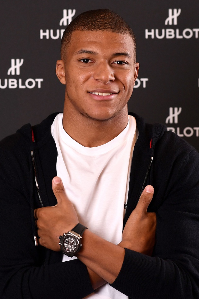 Футболист Килиан Мбаппе в костюме с часами на руке