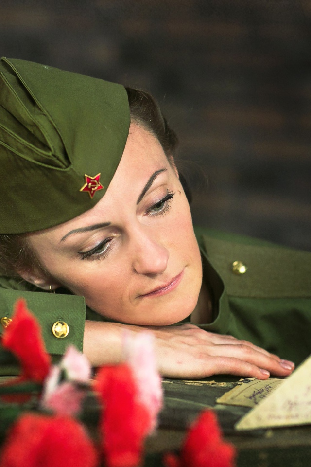 Girl in uniform with a bouquet of carnations and a letter for May 9