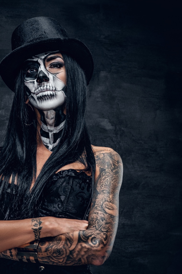 Девушка с гримом на лице с татуировками на руках