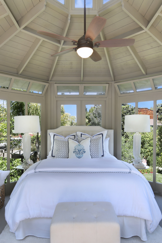 Большая спальная комната с окнами и белой кроватью 