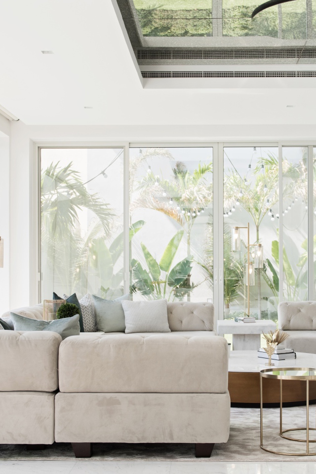 Большая гостиная комната с диваном и большими окнами