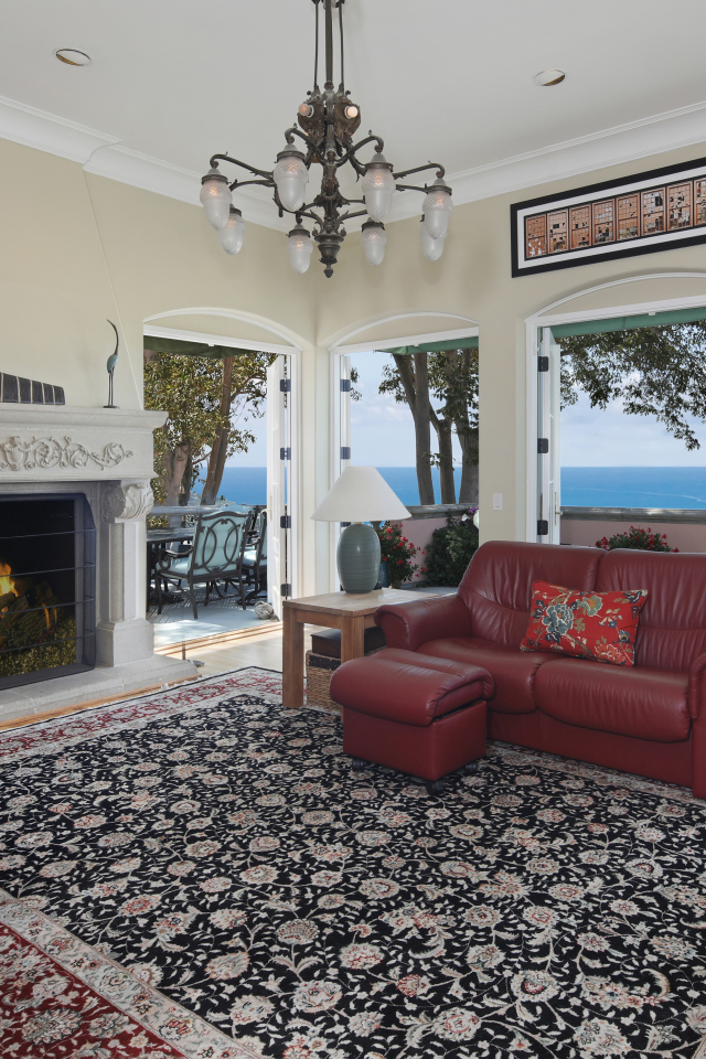 Гостиная с кожаным диваном, большими окнами и камином 