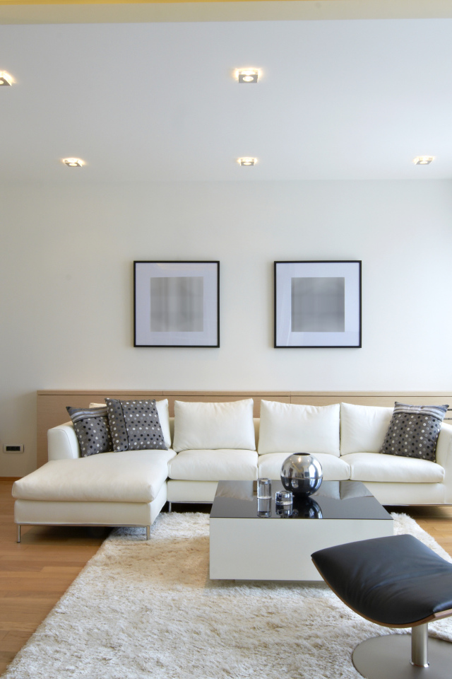 Гостиная комната с белым кожаным диваном и черным креслом у окна