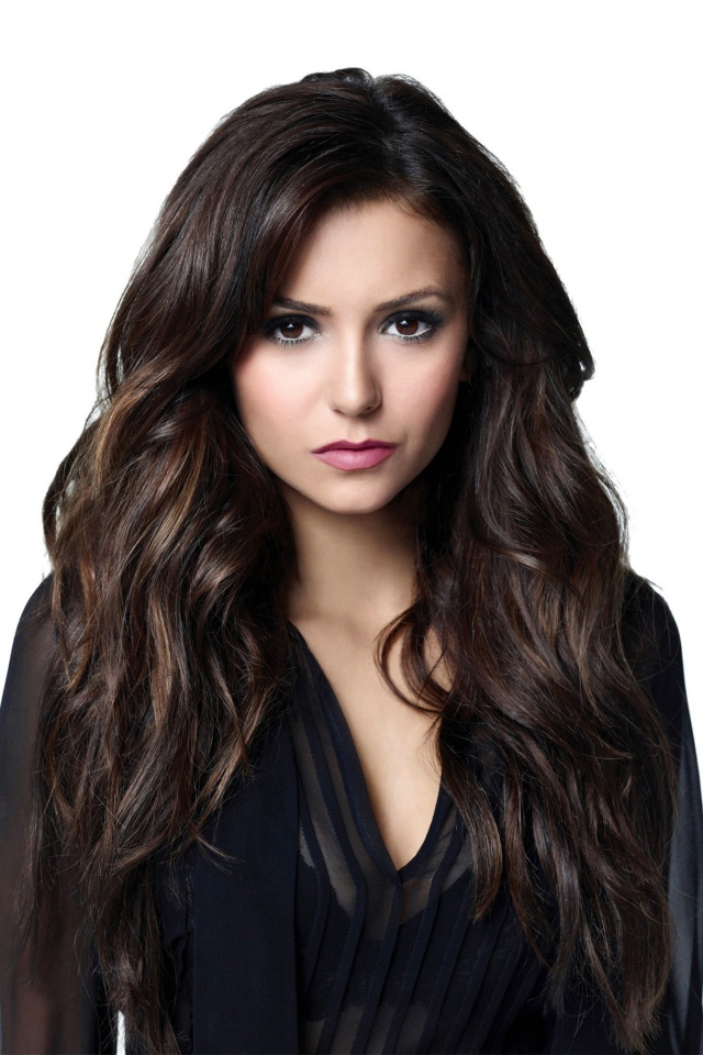 Длинноволосая девушка актриса Нина Добрев на белом фоне