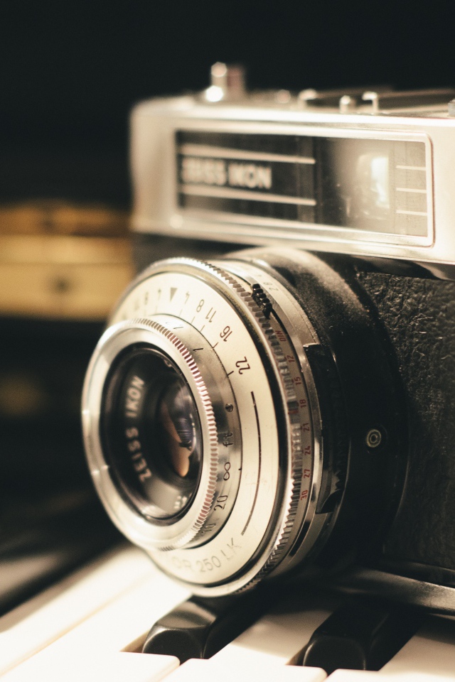 Старый фотоаппарат Zeiss Ikon стоит на клавишах пианино