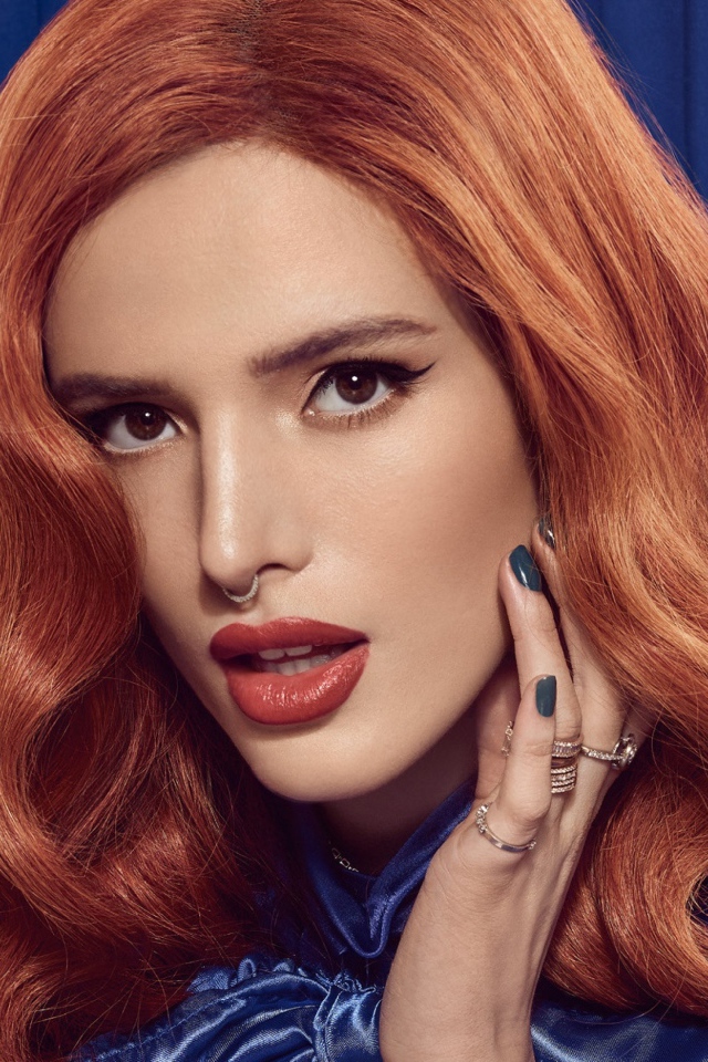 Рыжеволосая актриса Белла Торн на синем фоне