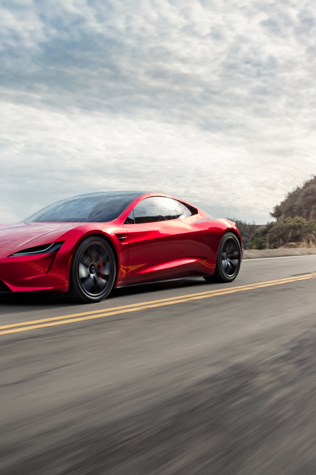 Красный автомобиль Tesla Roadster едет по трассе 