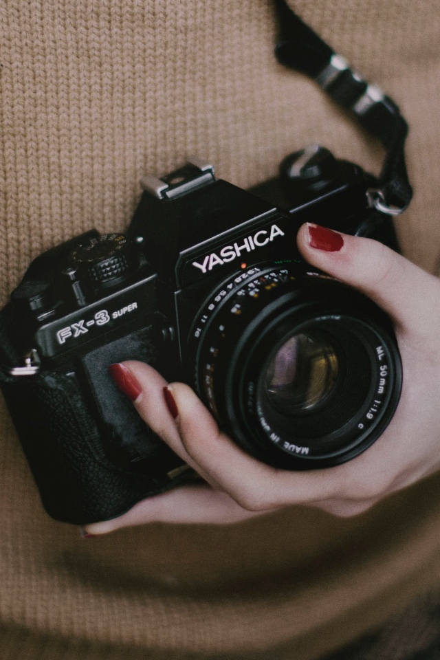 Зеркальная камера Yashica FX-3 в руках у девушки