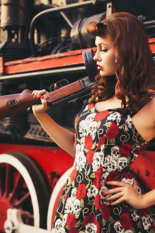 Девушка ретро с автоматом в руке  у тепловоза 