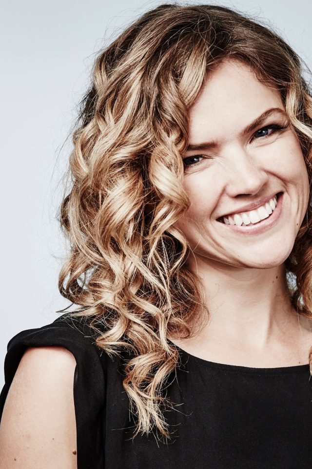 Улыбающаяся блондинка, актриса Эрин Ричардс на сером фоне