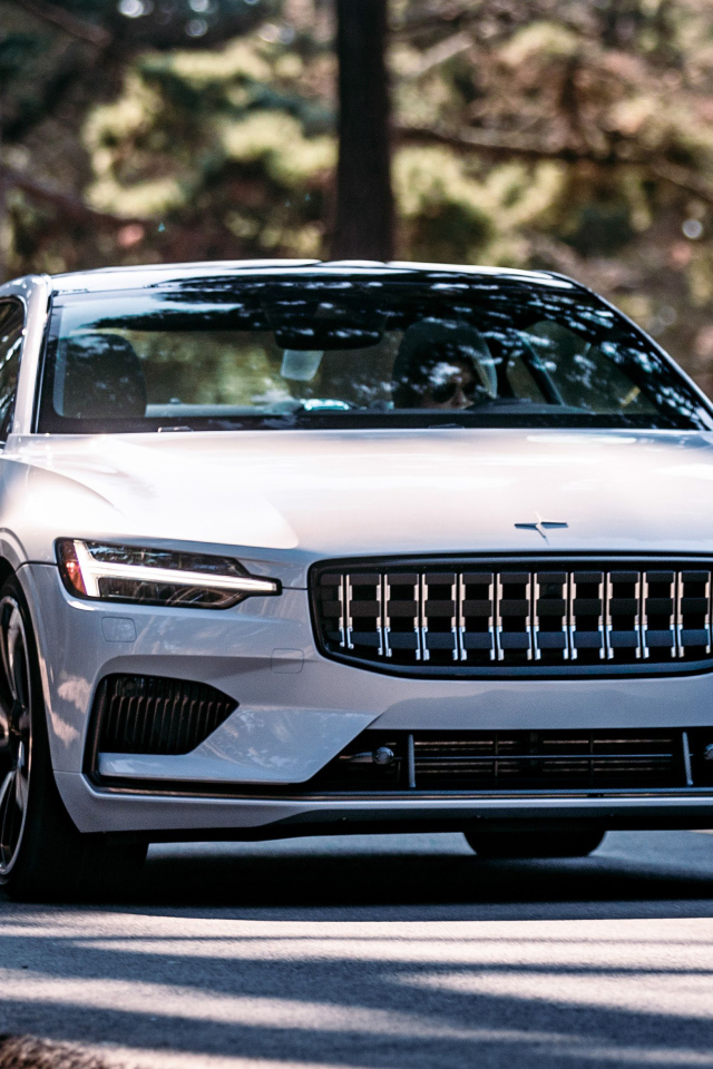 Белый автомобиль Polestar 1 2021 года едет по дороге