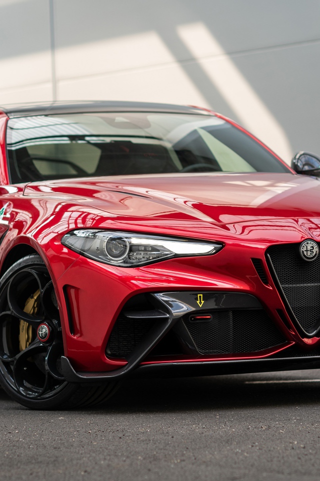 Красный автомобиль Alfa Romeo Giulia GTAm 2020 года у гаража