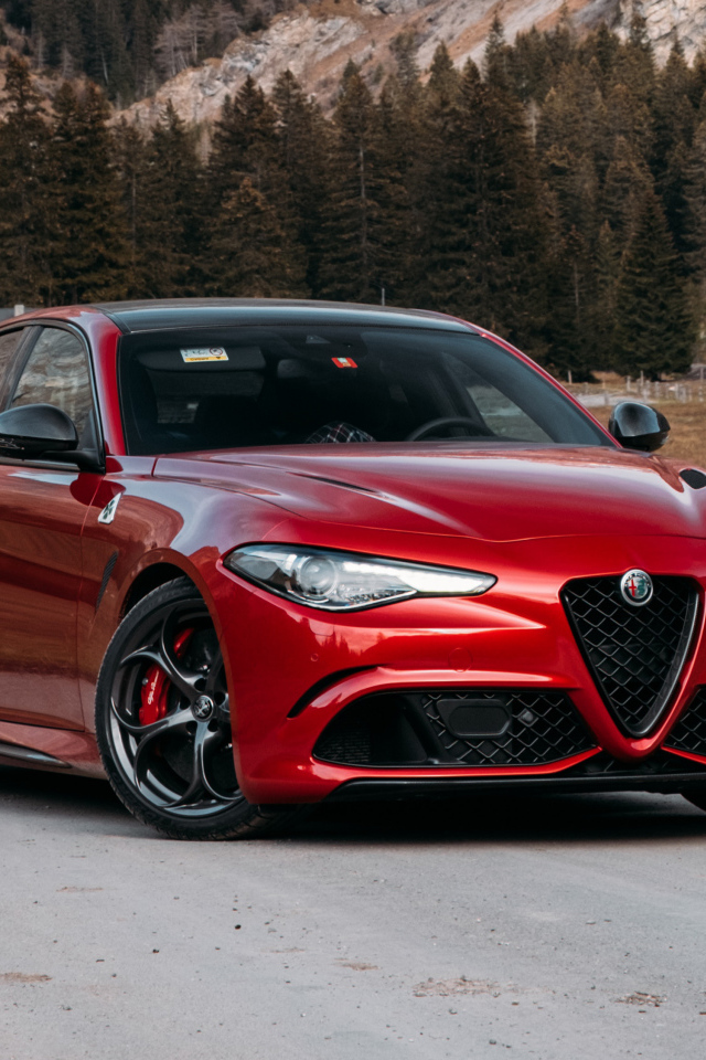 Красный автомобиль Alfa Romeo Giulia Quadrifoglio 2021  года на фоне гор